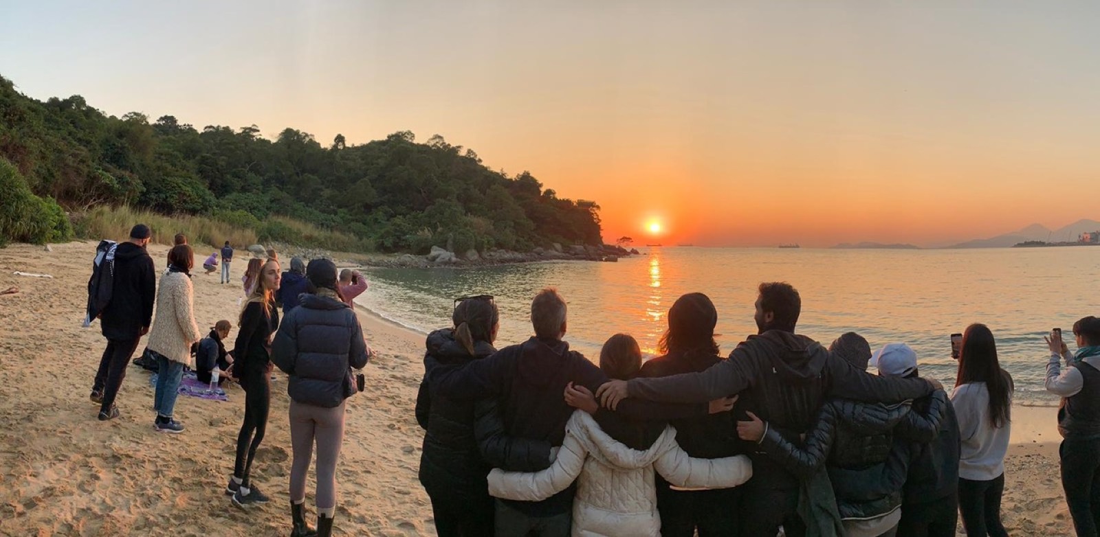 Group watching the sunset together on the beach
