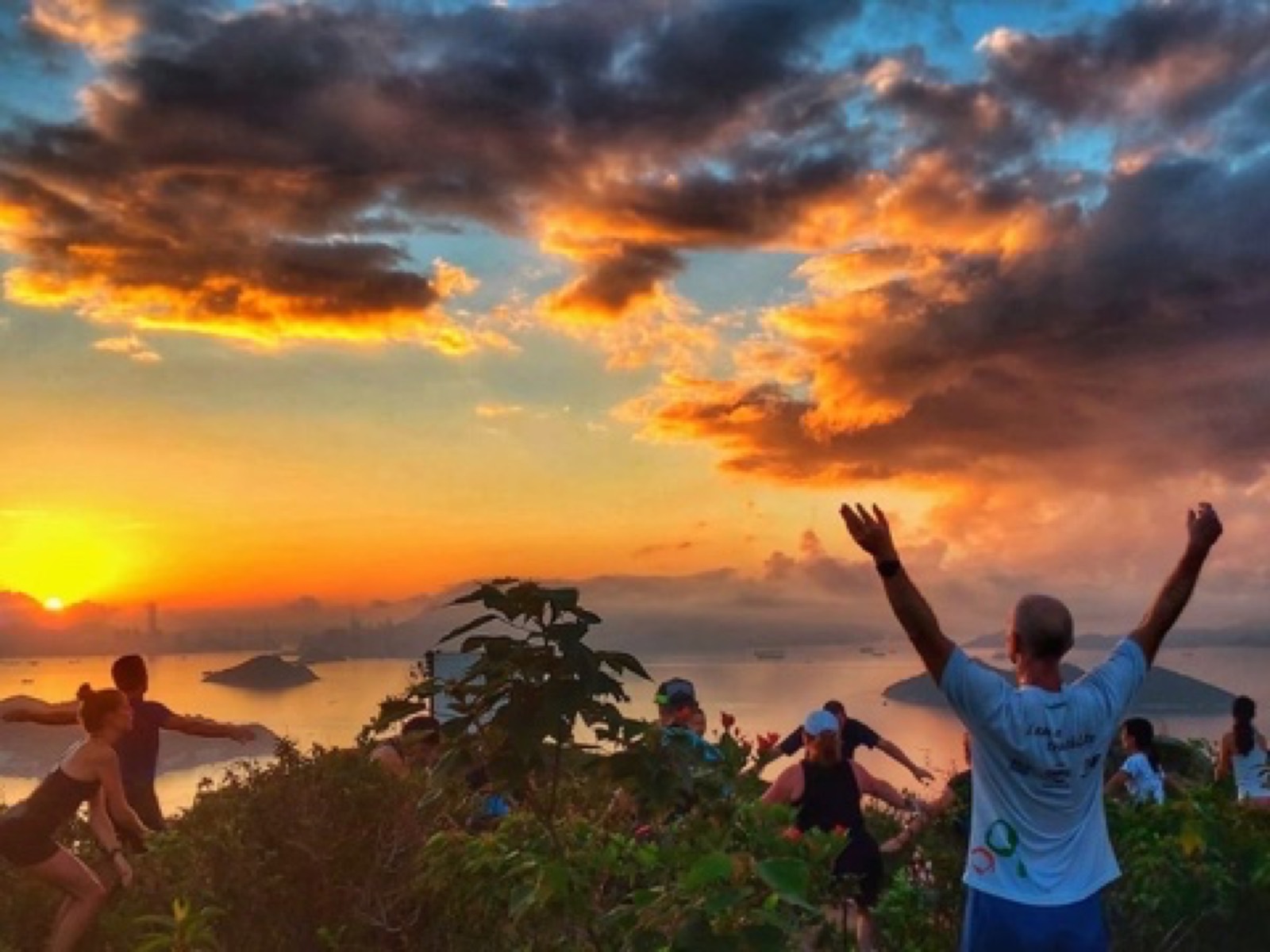 Group moving at sunrise above the bay